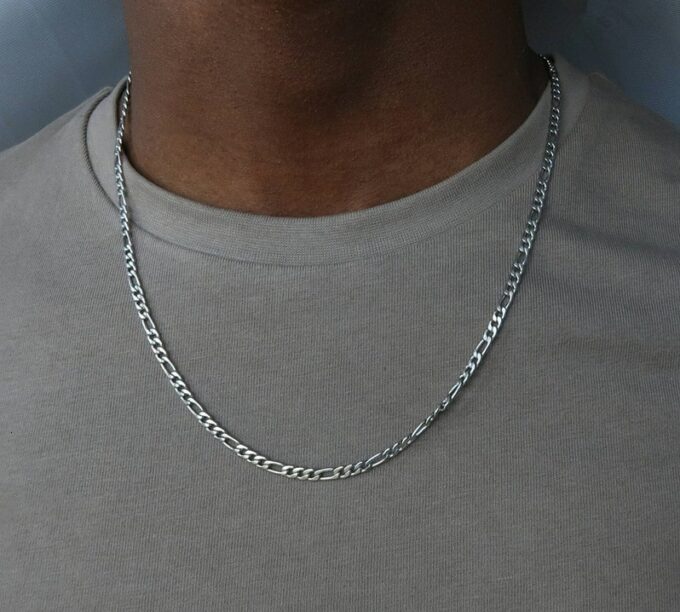 N3575e Chaine figaro homme Acier inoxydable argent 50 cm - Bijoux Colliers Hommes en ligne Ninanina Collier homme chaîne Figaro en acier inoxydable, finition argentée, 50 cm, signé Ninanina portée par un homme au tee shirt blanc