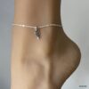 Chaîne de cheville en argent massif 925 avec design plume portée par une femme en gros plan - Bijou élégant et fait main en France