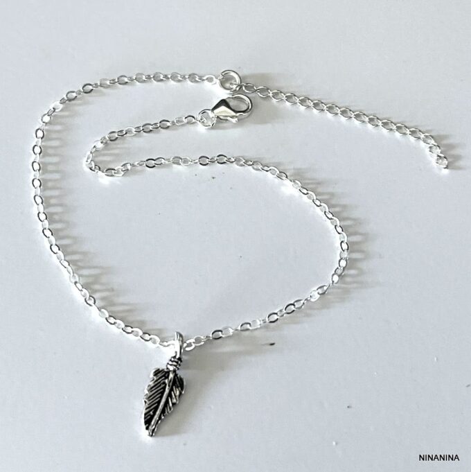 Détail du pendentif plume en argent 925 massif sur la chaîne de cheville fine - Accessoire féminin et artisanal