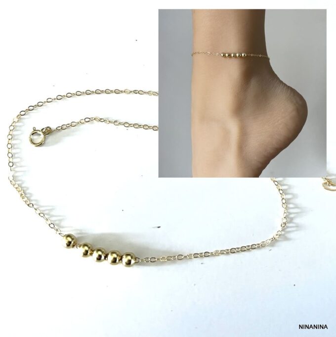 Chaîne de cheville en plaqué or avec perles rondes portée par une femme - Bijou chic et intemporel disponible chez Ninanina