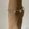 Bracelet de cheville artisanal argenté au design bohème chic avec motifs spirales et perles ovales argentées porté