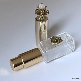 Bijou artisanal : Flacon de parfum de forme carrée en verre et métal doré avec pompe rehaussée d'une pierre de lune - Élégance et durabilité garanties par Ninanina