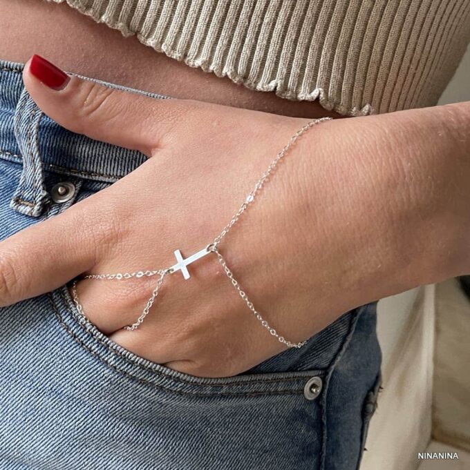 Bracelet bague style gothique avec chaîne pour main et croix en argent porté par une main qui sort de la poche d'un pantalon, fait main par Ninanina