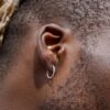 N6451 Créole homme argent 925 massif minimaliste 15 mm - Bijoux Boucles d oreilles Hommes en ligne Ninanina Boucle d’oreille créole en argent 925 massif petit diamètre et finition lisse pour un style épuré portée par un homme de couleur de profil, accessoire intemporel pour hommes