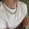 Zoom sur la chaîne en acier inoxydable avec design gros maillons grain de café portée de profil - Bijou chic et robuste