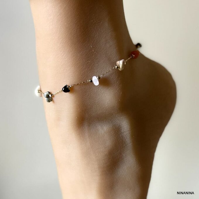 Chaîne de cheville multicolore en pierres naturelles et laiton doré porté sur pied en gros plan - Bijou artisanal fait main en France signé Ninanina