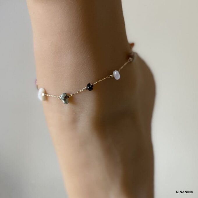Gros plan sur Bracelet de cheville en pierres naturelles multicolores et laiton doré porté - Bijou féminin élégant signé Ninanina