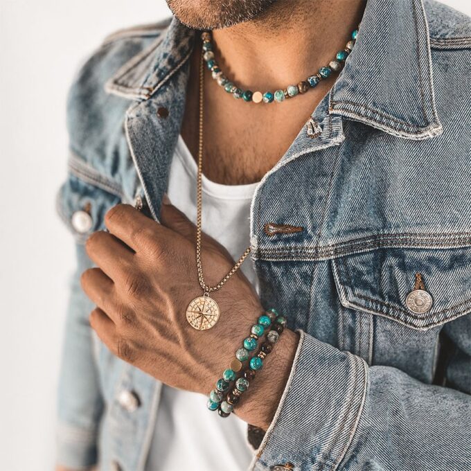 N7994e Collier Pierre Naturelle Homme Jaspe Bleu Hématite Or - bijoux Colliers en ligne Ninanina Laissez-vous séduire par l’élégance et la sobriété de ce Collier Pierre Naturelle Homme Jaspe Bleu Hématite Or  ! Long de 45 cm, il se compose de perles rondes en jaspe bleu et de rondelles en hématite doré et se termine par un fermoir solide qui garantit un ajustement sécurisé et confortable. Les perles de jaspe bleu de 8 mm de diamètre sont soigneusement sélectionnées pour leur couleur vibrante et leur finition lisse. Chaque perle est polie à la main pour créer une surface brillante et agréable au toucher. Les perles d'hématite dorée ajoutent une touche de luxe et de sophistication à l'ensemble. La combinaison du jaspe bleu et de l'hématite crée un contraste saisissant qui attire le regard.