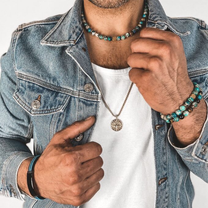 N7994f Collier Pierre Naturelle Homme Jaspe Bleu Hématite Or - bijoux Colliers en ligne Ninanina Laissez-vous séduire par l’élégance et la sobriété de ce Collier Pierre Naturelle Homme Jaspe Bleu Hématite Or  ! Long de 45 cm, il se compose de perles rondes en jaspe bleu et de rondelles en hématite doré et se termine par un fermoir solide qui garantit un ajustement sécurisé et confortable. Les perles de jaspe bleu de 8 mm de diamètre sont soigneusement sélectionnées pour leur couleur vibrante et leur finition lisse. Chaque perle est polie à la main pour créer une surface brillante et agréable au toucher. Les perles d'hématite dorée ajoutent une touche de luxe et de sophistication à l'ensemble. La combinaison du jaspe bleu et de l'hématite crée un contraste saisissant qui attire le regard.