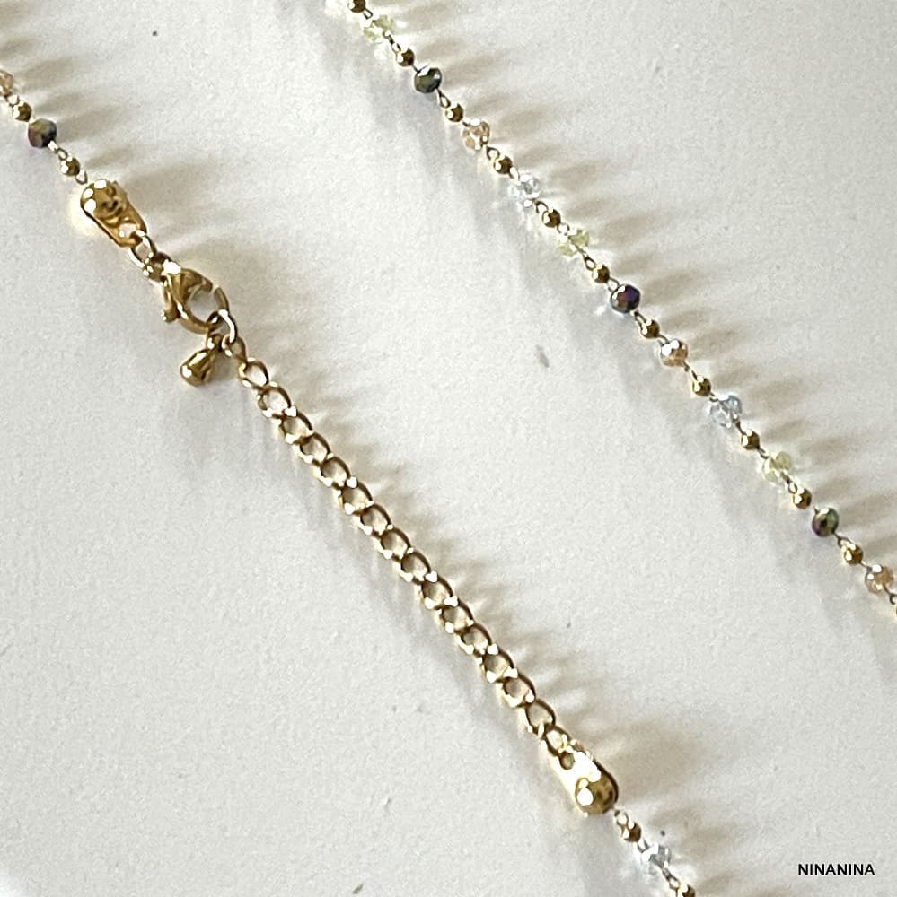 Détails du fermoir et chainette de réglage de la Chaine De tailles Or Perles Colorées Cristal Acier Doré Fait Main En France par Ninanina non portée sur fond blanc