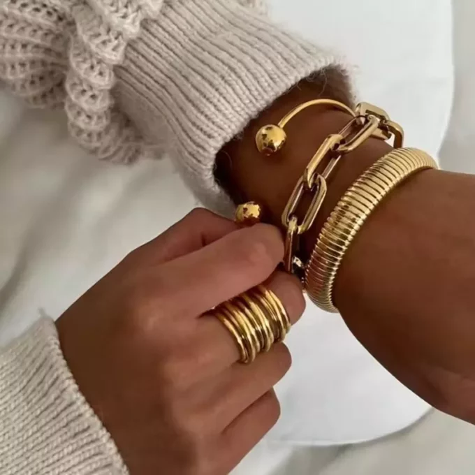 Bijou féminin : bague large en acier inoxydable doré multi rang portée par une femme - Élégance contemporaine et durable