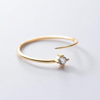 Gros plan sur Bague réglable pour orteil en argent 925 plaqué or et zirconium posée sur un fond blanc - Bijou féminin chic et artisanal signé Ninanina