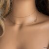 Gros plan sur bijou élégant pour femme, collier sautoir en or laminé gold filled 14k avec symbole infini porté en collier court avec 2 tours autour du cou