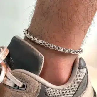 Chaîne de cheville pour homme en acier inoxydable torsadé portée sur un pied dans une basket - Bijou artisanal chic et intemporel signé Ninanina