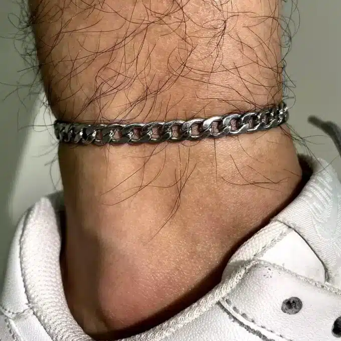 Gros plan sur Bracelet de cheville pour homme en acier inoxydable avec large maillons gourmette porté - Bijou artisanal signé Ninanina