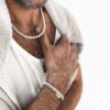 Collier en perles naturelles blanches porté par un homme - Bijou chic et moderne pour compléter une tenue.