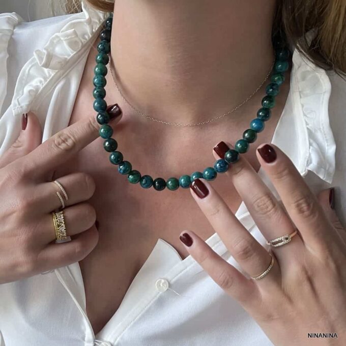 Collier Grosses Perles Bleu Vert En Chrysocolle 10mm Fait Main En France Ninanina porté par une femme à la main au vernis à ongles rouge