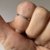 Zoom sur la bague de phalanges en acier inoxydable ornée de trois zirconiums portée - Accessoire élégant et moderne