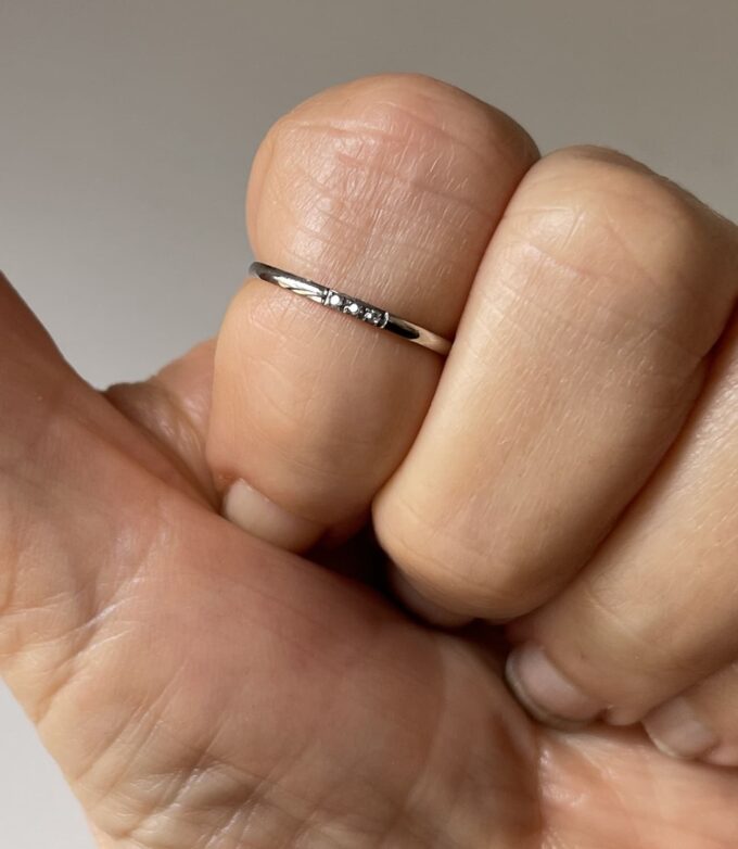 Zoom sur la bague de phalanges en acier inoxydable ornée de trois zirconiums portée - Accessoire élégant et moderne