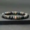Gros plan sur le Bracelet Heishi Homme Hematite Onyx Noir Et Bois Fait Main En France de Ninanina sur fond noir