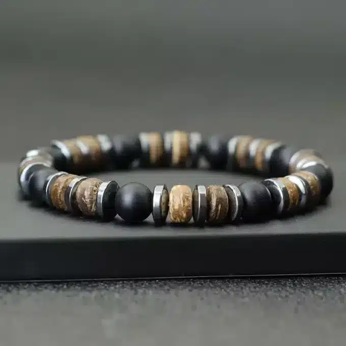 Gros plan sur le Bracelet Heishi Homme Hematite Onyx Noir Et Bois Fait Main En France de Ninanina sur fond noir