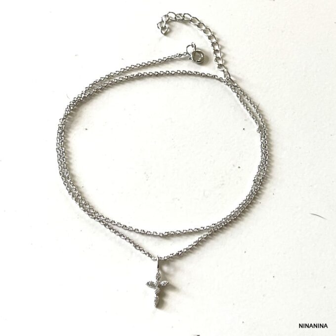 N8244f Chaine Pour Cheville Double Rang Croix Argent Et Zirconium - Bijoux de pieds en ligne Ninanina Détails de la Chaine Pour Cheville Double Rang Croix Argent Et Zirconium signée Ninanina non portée sur fond blanc