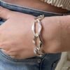 Gros Bracelet Argent Femme Larges Maillons Ovales porté sur une main dans la poche d'un jean