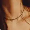 Zoom sur le Collier pour femme en pierres Œil de Tigre à facettes de 2mm portée par une femme aux cheveux longs - Bijou artisanal fait main en France