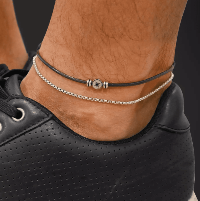 N8281d Bracelet De Cheville Homme Double Rang Cuir Et Acier Inoxydable Artisanal - Bijoux de pieds hommes artisanaux en ligne Ninanina Gros plan sur le Bracelet De Cheville Homme Double Rang Cuir Et Acier Inoxydable Artisanal signé Ninanina porté par un homme aux baskets noires