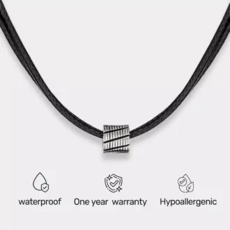 Collier Cordon Noir Artisanal Perle Cylindrique Acier Inox fait à la main en France posé sur un fond blanc