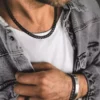 Chaine Acier Noir 7mm Homme Maille Gourmette 55cm faite main portée par un homme au tee shirt blanc. Un bijou robuste et élégant pour un style intemporel.